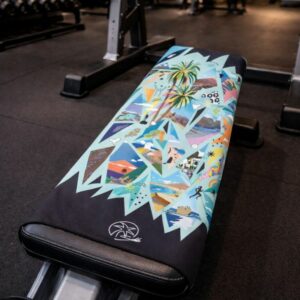 Toalla deportiva lReflejos colocada sobre banco de gimnasio, ligera yt compacta para entrenamiento