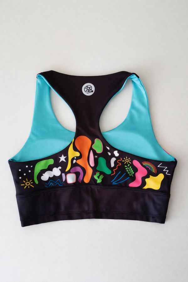 top-deportivo-mujer-equilibrio-espalda-sobre-mesa Detalle trasero del top deportivo mujer Equilibrio mostrando espalda tipo nadadora y acabado estructurado en tejido reciclado.