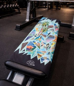 Toalla deportiva lReflejos colocada sobre banco de gimnasio, ligera yt compacta para entrenamiento