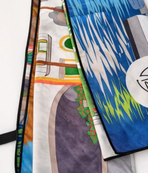 Detalle de toalla de microfibra con ilustración de casas y paisaje de Puerto de Mogán