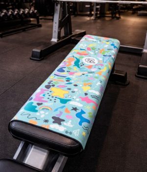 Toalla deportiva reciclada equilibrio sobre banco de gimnasio durante el entranamiento